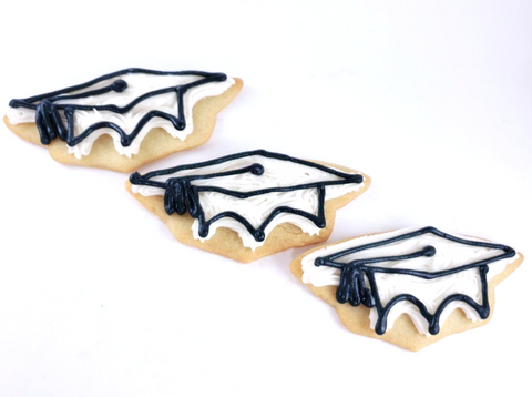 3 buttercream graduation cookies on white background