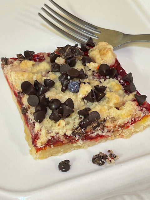 Raspberry Bar with crumble and chocolate chips on white plate with fork