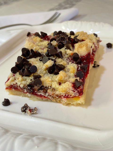 Raspberry Bar with crumble and chocolate chips on white plate